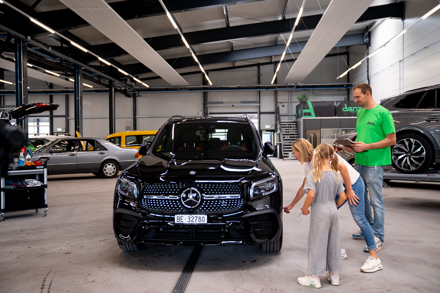 Mutter und Kind begutachten das saubere Auto.